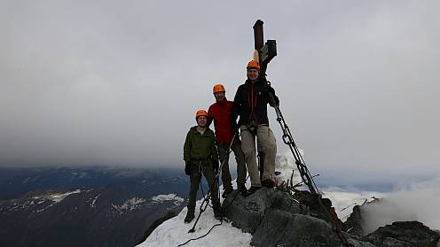 Trotz allem haben wir es alle drei nach ganz oben auf den Großglockner geschafft. Im Hintergrund lässt sich gut erahnen, dass schon bald nach unserem Besuch der Gipfel wieder in Wolken gehällt war. Wir waren froh, dass wir so früh am Tag unterwegs waren.